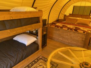 Interior of covered wagon with bunk beds and coffee bar